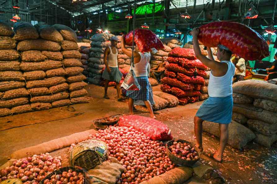 Kolkata: Workers sort onions at a godown of a wholesale market as...