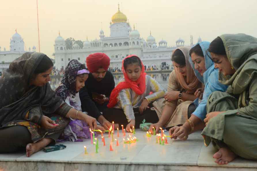 Patiala: Devotees light candles near 'Sarovar Sahib' on Diwali at...